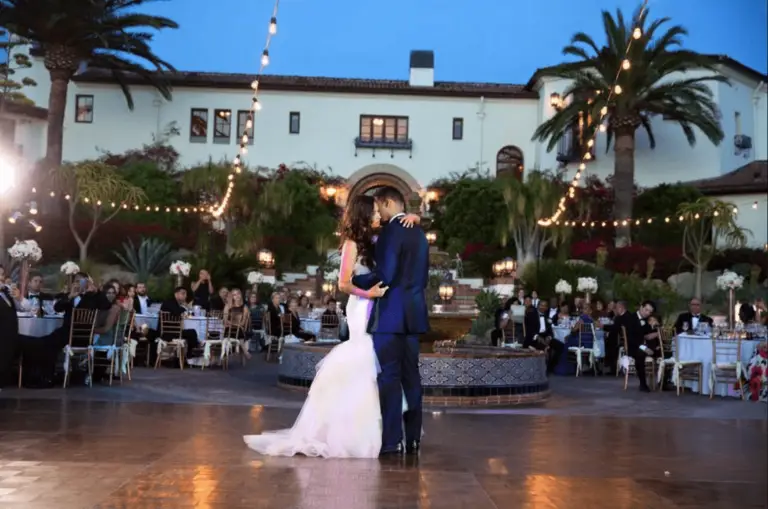 Couple dancing at outdoor wedding reception venue.