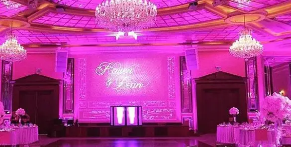Lavishly decorated pink wedding venue with chandeliers.