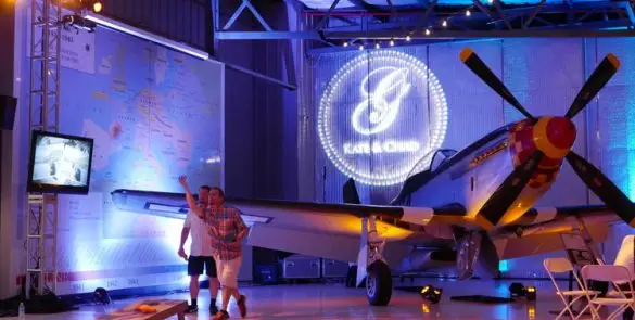 Airplane in hangar with illuminated logo display.