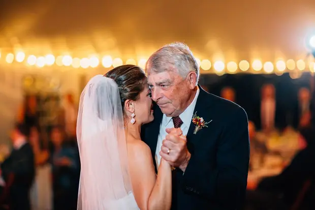 Bride dancing with elderly man at wedding