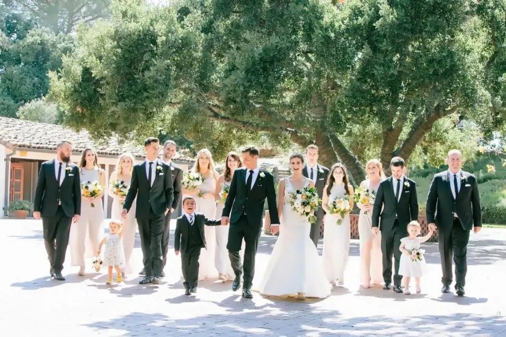 Wedding party poses under lush trees