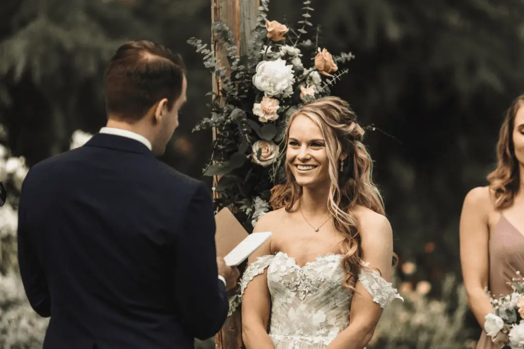 Bride and groom exchanging vows outdoors.