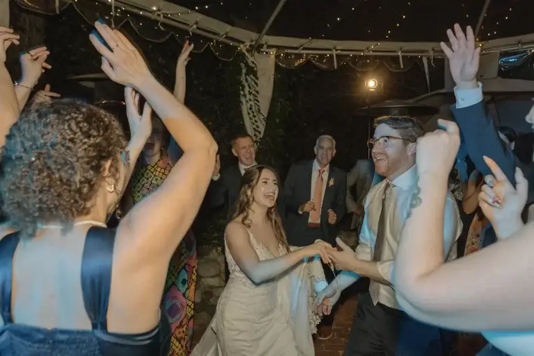 Bride and groom dancing at lively wedding reception.